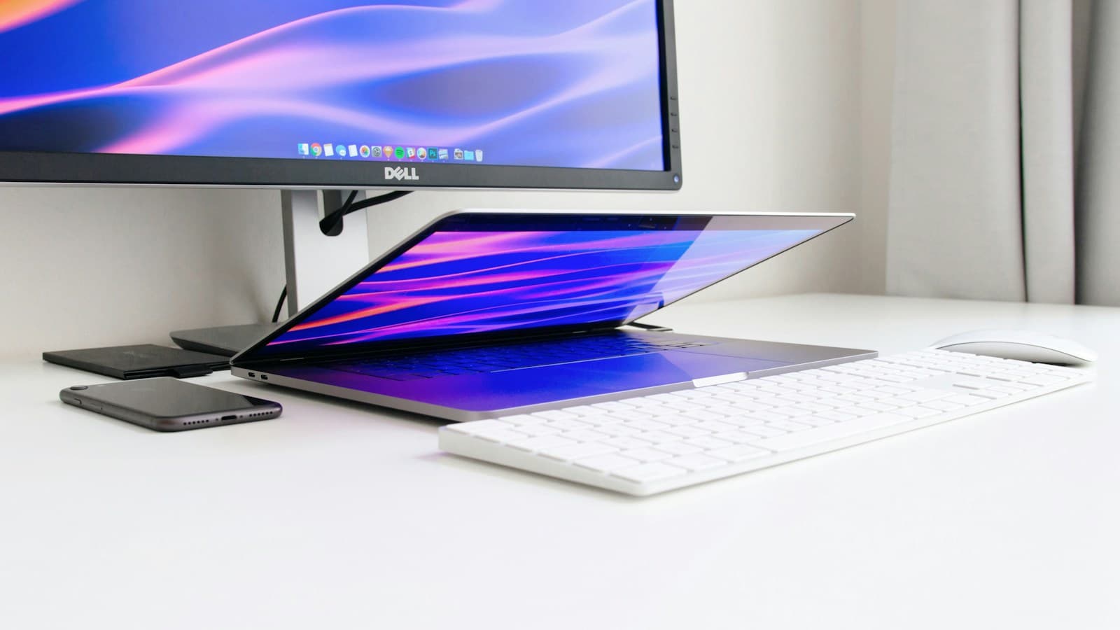 Monitor a notebook na pracovnom stole v tlmenom svetle