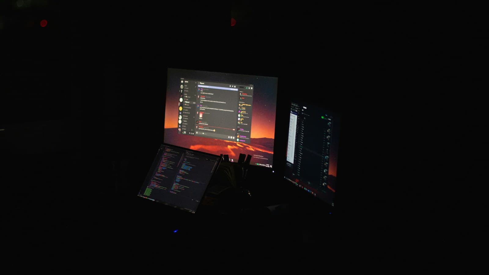 Ein Arbeitsplatz mit Laptop und Monitor, auf denen Programmcode angezeigt wird